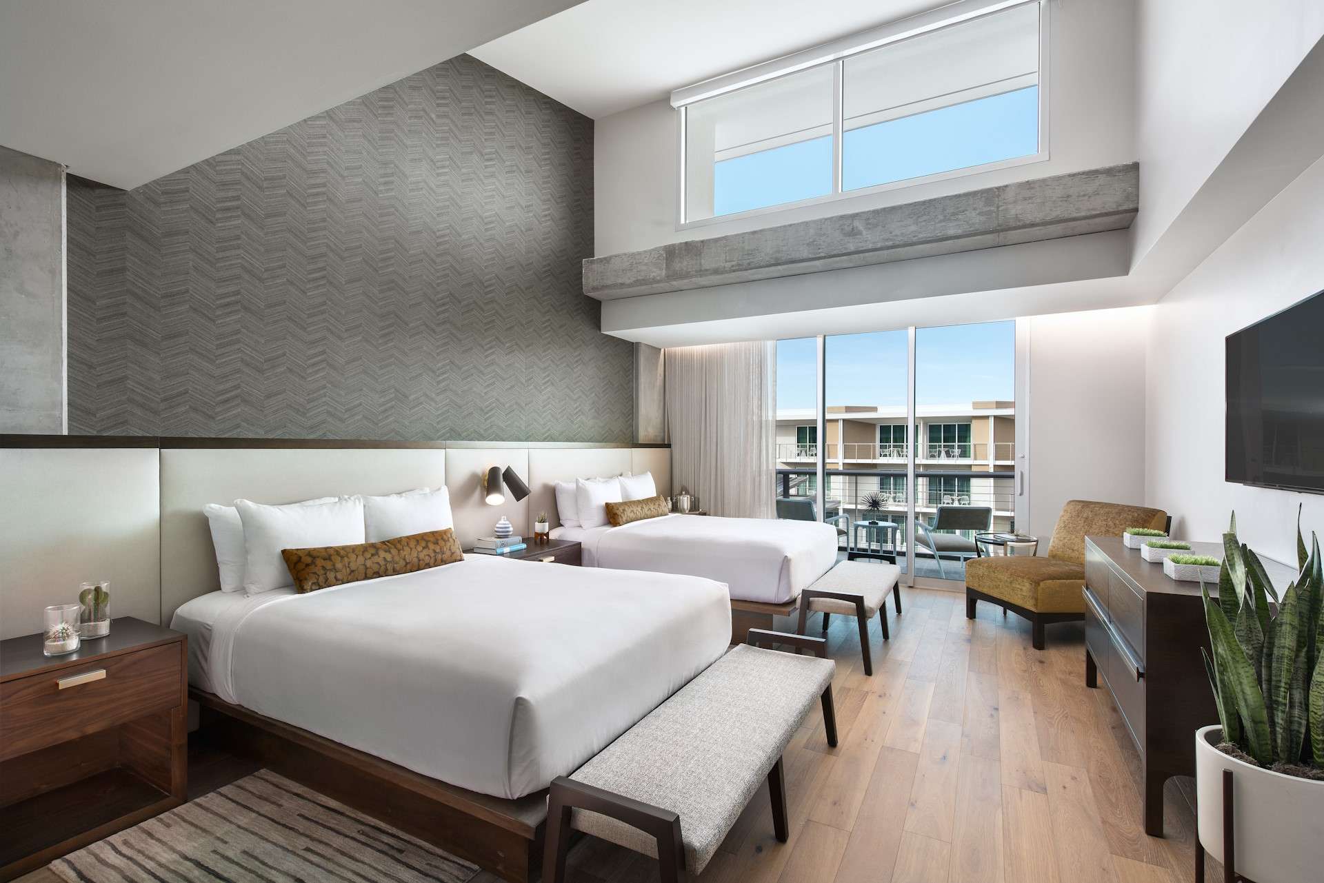 Two beds side by side with large glass sliding door to the outside.