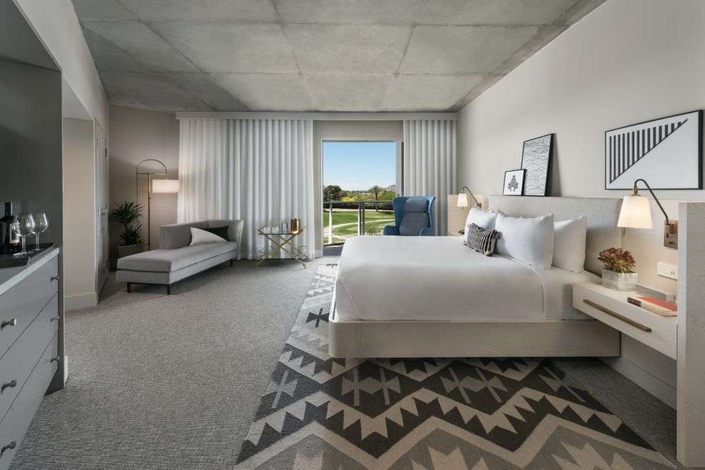 a furnished room featuring a bed and curtains surrounding a glass door
