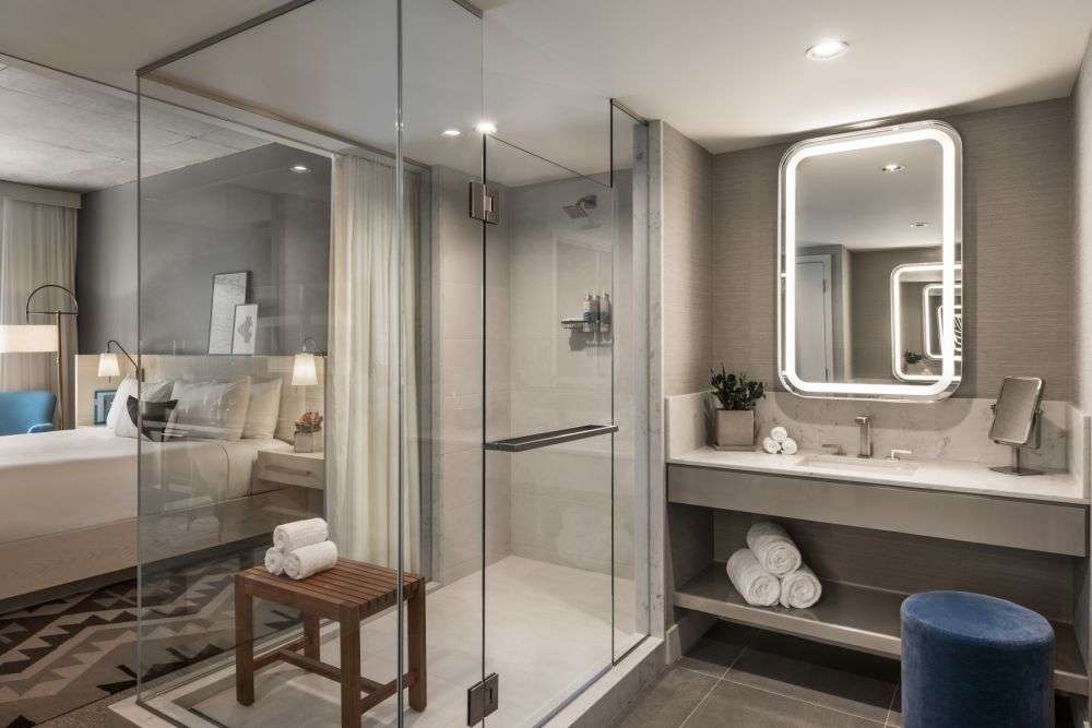 a bathroom with a large mirror and towels on the sink
