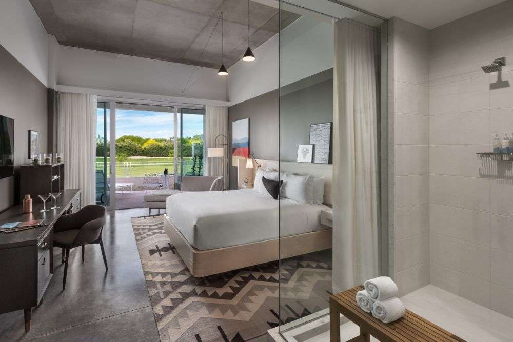 a bedroom featuring a bathroom, bed, and sliding glass door.