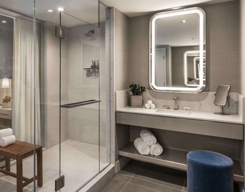a bathroom with a large mirror and towels on the sink