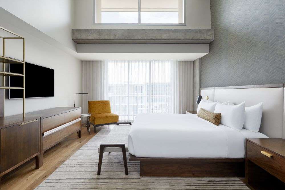 a bedroom with a large bed and curtains over a window