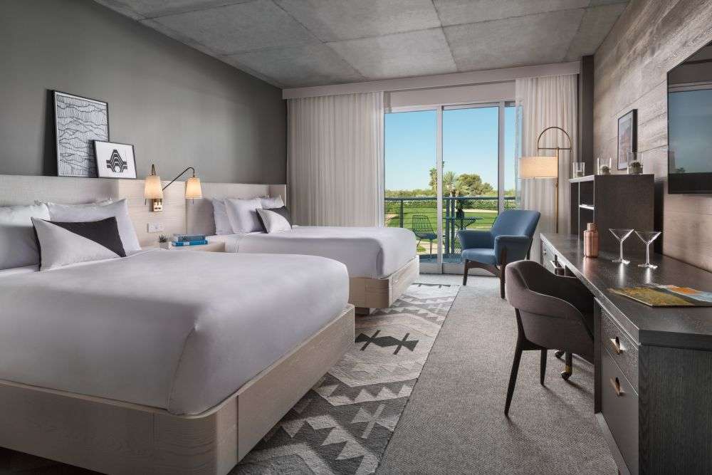 a room featuring two beds and a sliding door to the outside