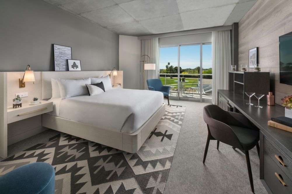 a room with a bed and sliding glass door to the outside