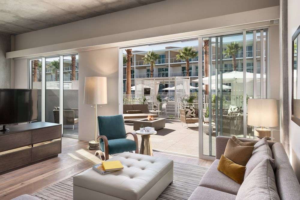 a room featuring a couch, chairs, and sliding glass door to the outside