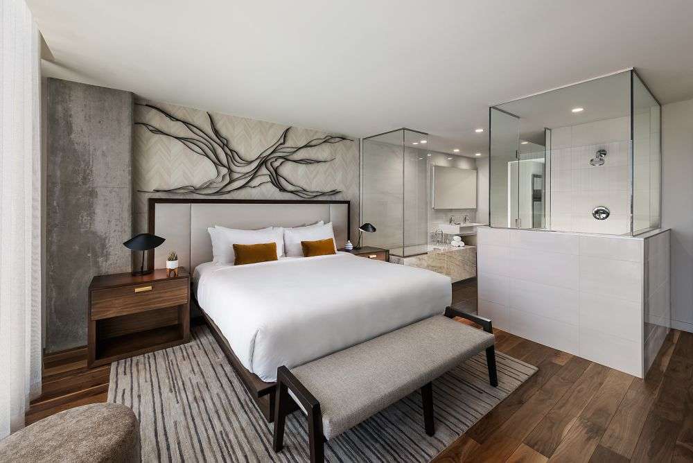 a bedroom featuring a large bed that has a connecting bathroom