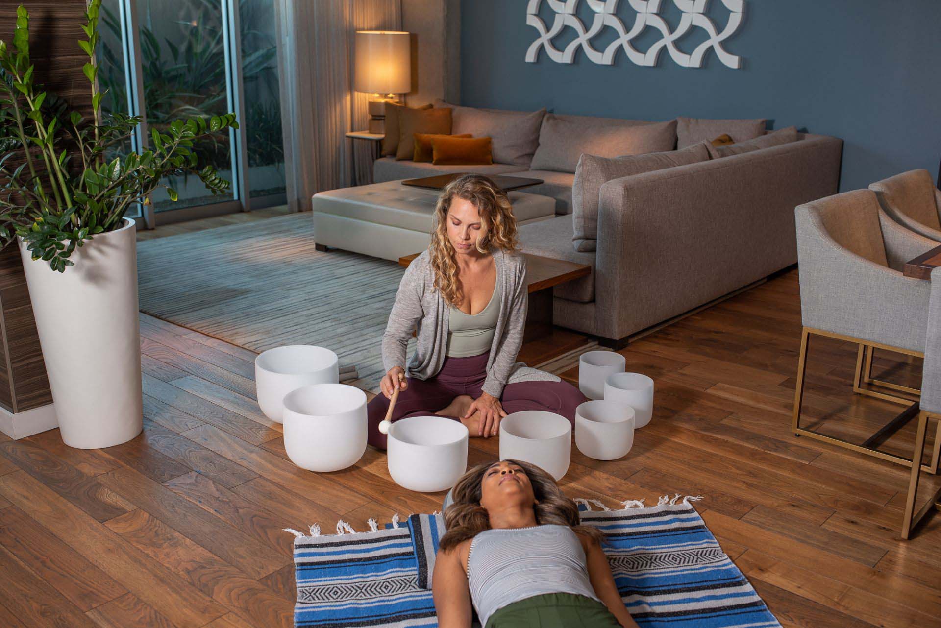 Woman sitting on the floor with a white bowl.