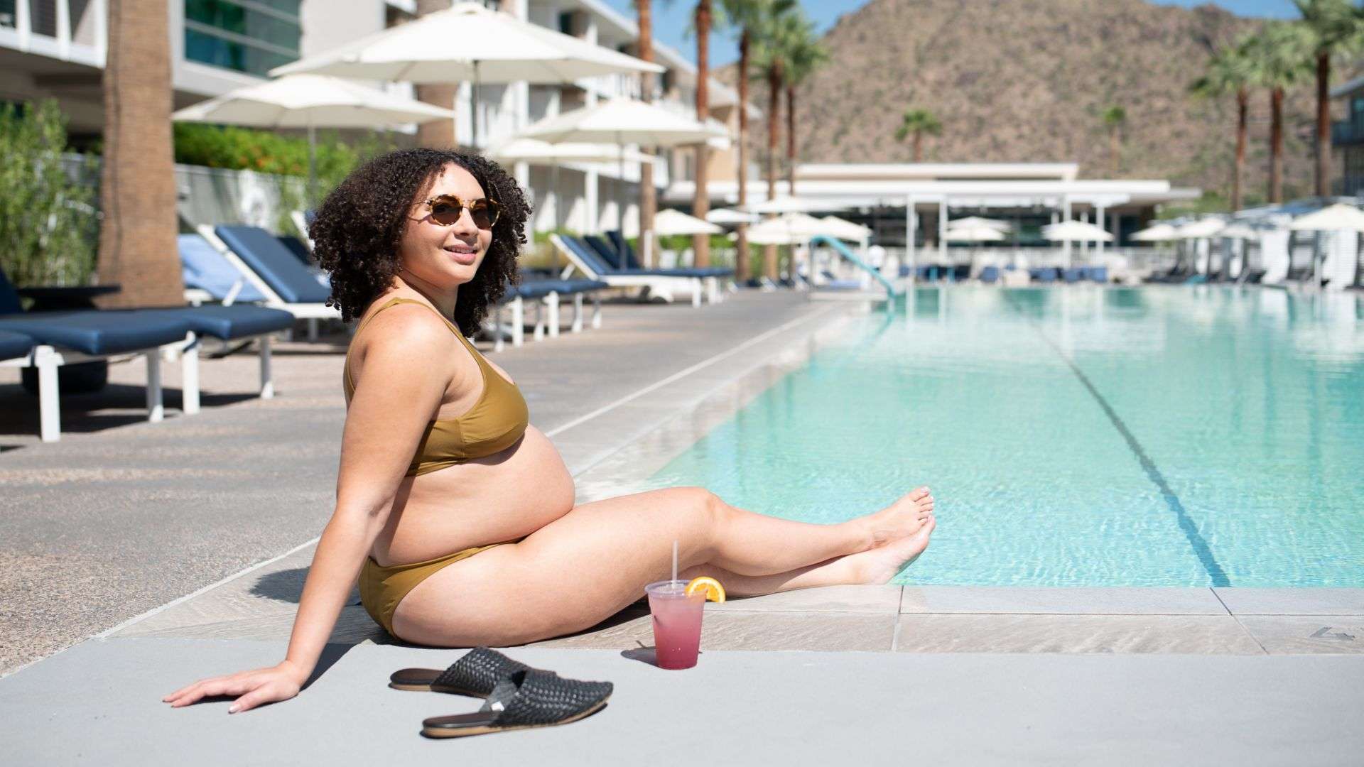 Woman in bikini relaxing by poolside.