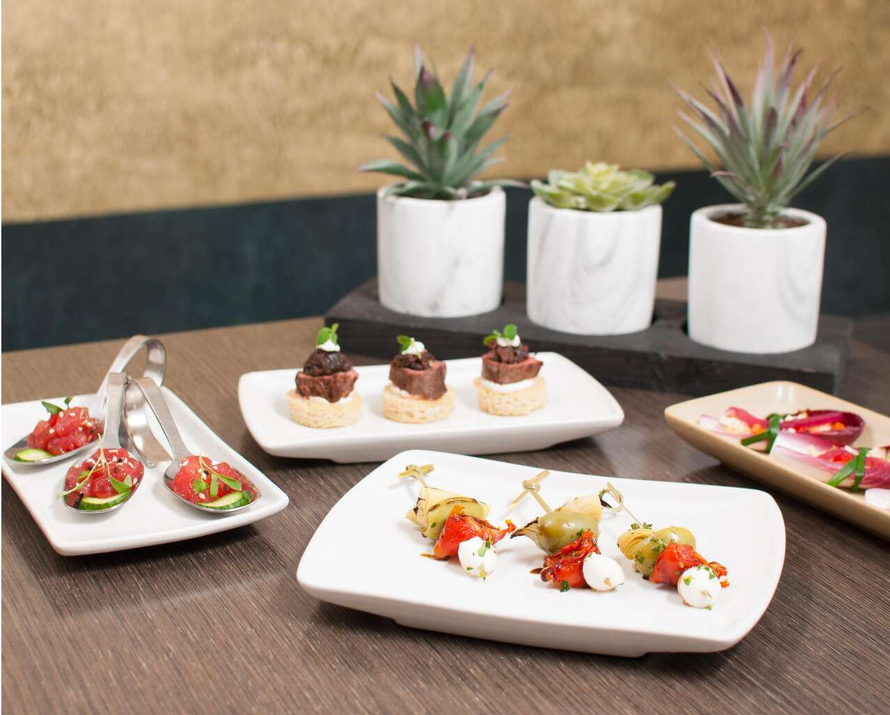 Plates of food and a plant on a table, framed by the beauty of Mountain Shadows.