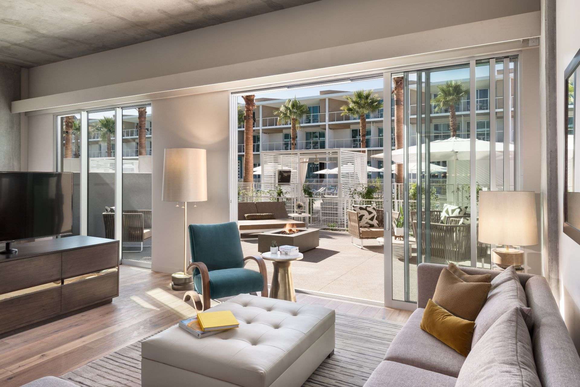 a room featuring couches, a TV, and large sliding glass door to the outside