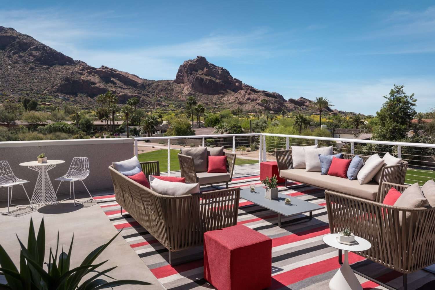 an outside sitting area featuring multiple chairs and mountains in the back
