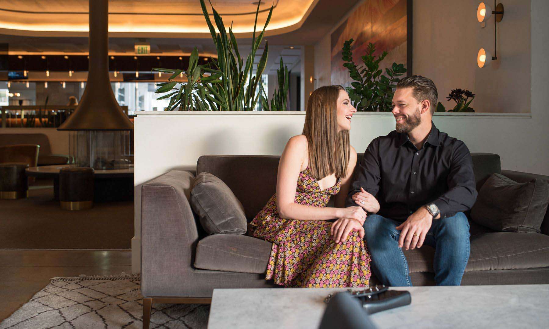 A couple relaxes on a couch in Mountain Shadows hotel lobby.