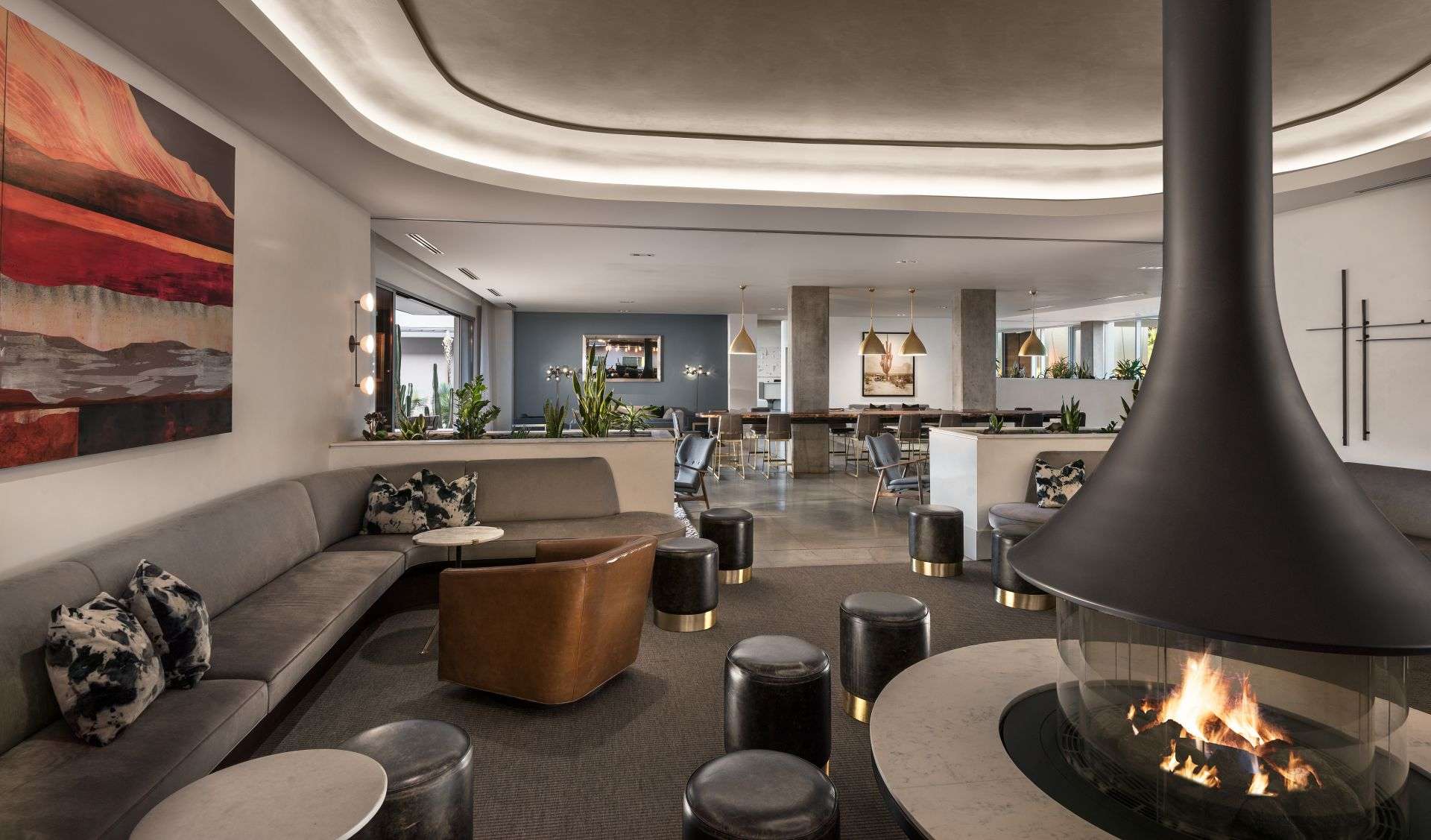 A living room with multiple chairs and tables and a fireplace.