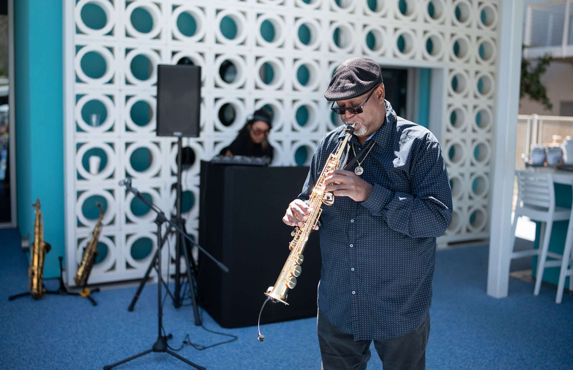 Man playing music outside poolside.