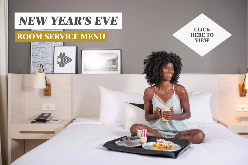 New Year's Eve Pop-Up with woman on bed with room service food