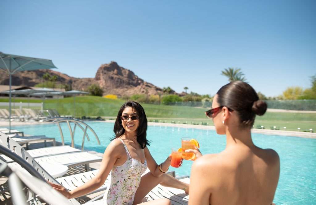 two women with cocktails seated at Sunset Pool