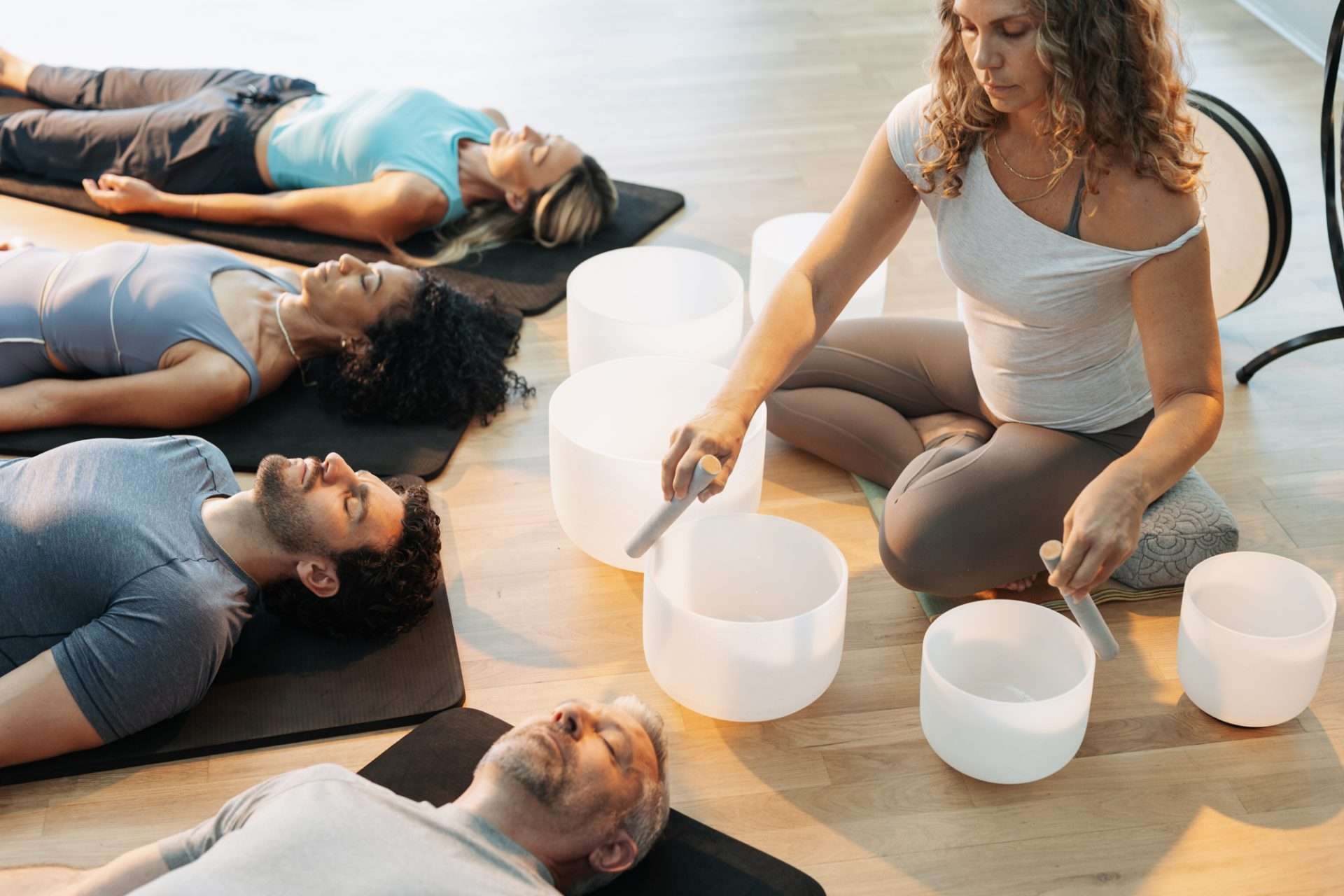woman leading sound healing session with bowls