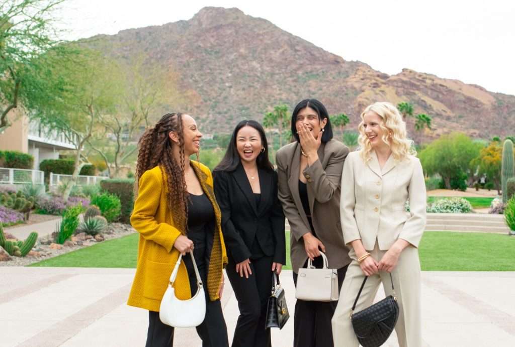 four women wearing suits