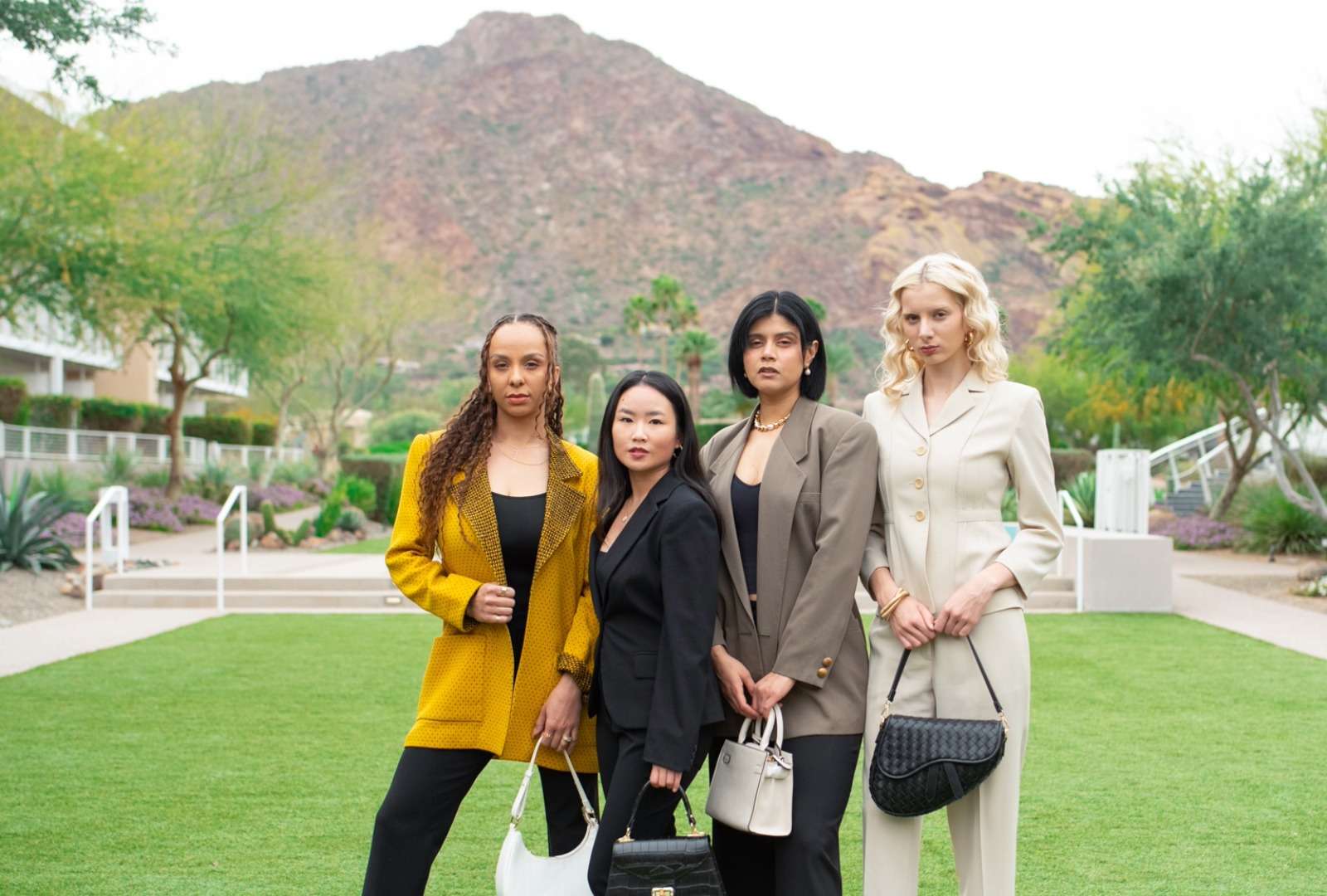 four women wearing suits