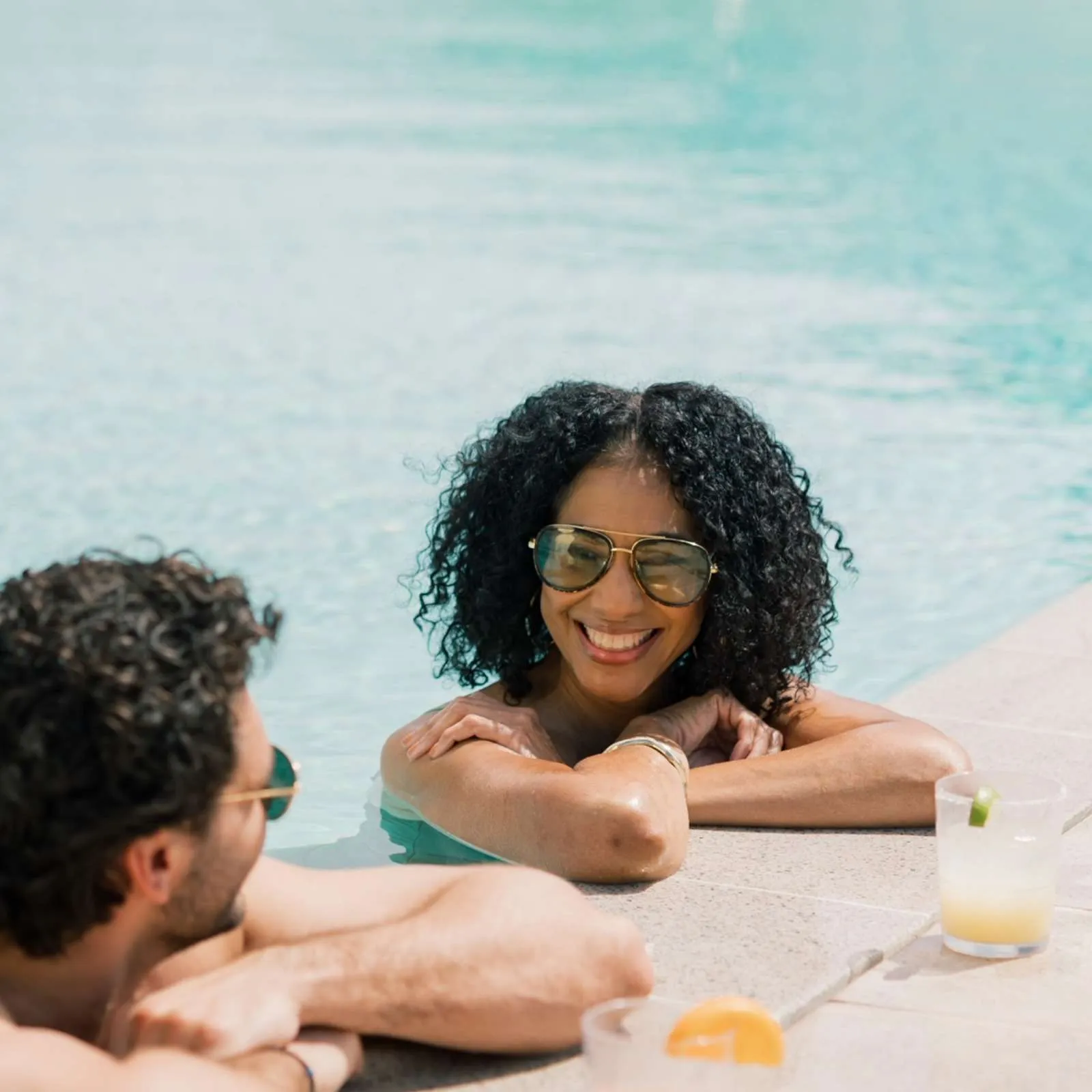 couple at the Sunset Pool with cocktails