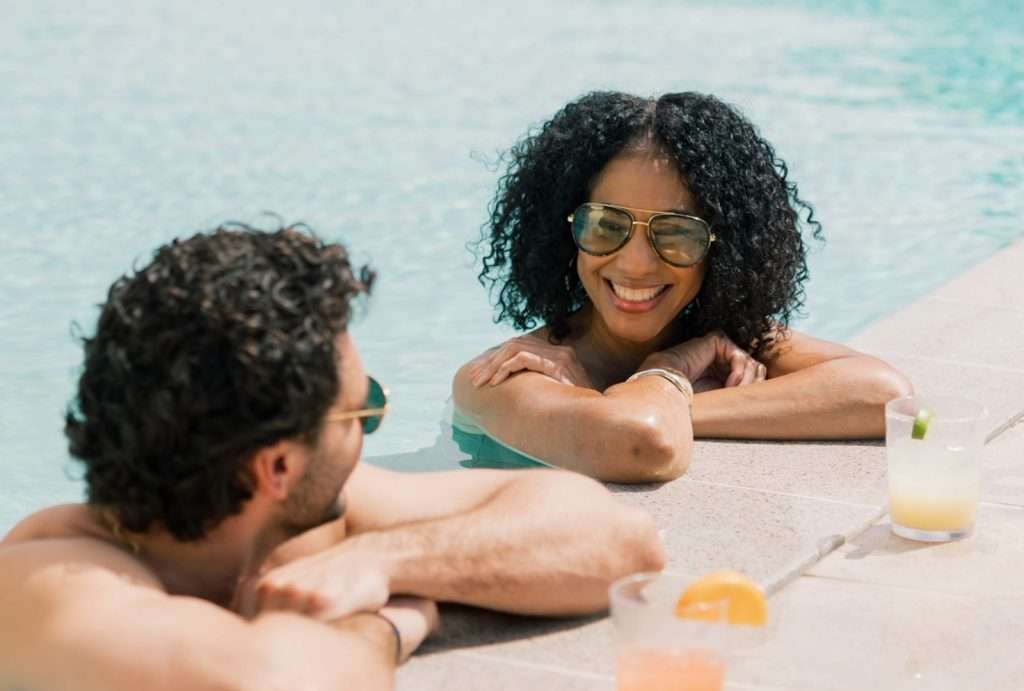 couple in the Sunset Pool with cocktails